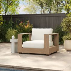 a wooden chair sitting on top of a patio next to a pool