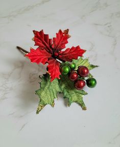 a red and green christmas decoration on a marble surface