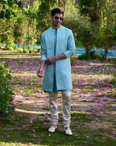 Step into your next haldi, mehndi, or sangeet occasion in style with the akbari bundi set. This ensemble features a powder blue front-open nehru jacket paired with a matching powder blue kurta. The combination creates a harmonious and elegant look, while the off-white churidar completes the set with a classic touch. The powder blue nehru jacket is designed with a sleek front-open silhouette, offering a contemporary twist on a traditional style. Its light and refreshing color is perfect for festive occasions, adding a touch of sophistication without being overwhelming. The matching powder blue kurta continues the theme, providing a cohesive and comfortable fit. The front-open design allows for ease of movement, ensuring you're as relaxed as you are stylish. White Churidar, Blue Kurta, Nehru Jacket, Nehru Jackets, Bespoke Tailoring, Open Design, Churidar, Powder Blue, Cotton Silk