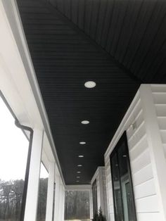 an empty porch with white walls and black ceiling