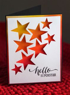 a white card with red and gold stars on it, sitting on a red surface