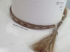 Horsehair hat band:: IMPRESSIVE ! All natural horsehair hat band: stunning design, genuine Horsehair in the BOLDEST Western design. Color : Cinnamon brown and natural white ** all natural horsehair Unique, distinctive and exceptional quality Cowboy horsehair hat band! * Everything you want in a Horsehair hat band. * This is a 5 strand horsehair hat and that is about 5/8 inches wide. * Easy adjusts You will find it easy to adjust to fit most any size hat with sliding knots. Brings out your spirit Adjustable Brown Mini Hats Country Style, Adjustable Brown Country Mini Hat, Adjustable Brown Mini Hat For Rodeo, Bohemian Adjustable Beige Mini Hat, Adjustable Bohemian Beige Mini Hat, Adjustable Flat Brim Hat With Fringe, Bohemian Beige Adjustable Mini Hat, Rustic Adjustable Handmade Hat Bands, Handmade Adjustable Beige Mini Hats