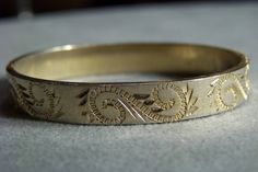 I am offering you this lovely vintage gold tone classic bangle bracelet. It features incredible design work, all with a very uniform etched designs, flowers and leaves around the entire top surface of this very high end spectacular bangle bracelet. It has a very appealing design and it measures app. 2 1/4 inches in diameter. It is measuring app. 1/4 inch wide. Buyer pays all shipping and handling fees, we will always combine shipping. Classic Bangles, Vintage Fans, Etched Designs, Vintage Yellow, Vintage Gold, Etching, Bangle Bracelets, Cuff Bracelets, Gold Tones