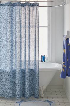 a bathroom with a blue shower curtain next to a bath tub