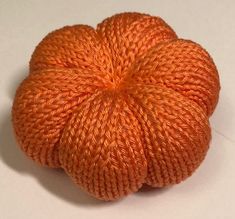 an orange ball of yarn sitting on top of a table