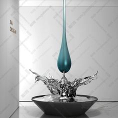 a blue water droplet in a black bowl on a white countertop next to a wall