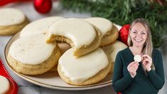 a woman standing in front of some cookies on a plate with frosted icing