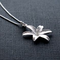 "Sterling Silver Lily Flower Pendant Necklace, Mothers Day Jewelry Gift, Anniversary Necklace, Botanical Blossom Nature Charm, FREE SHIPPING OVERVIEW: * Beautiful, elegant, bright and sturdy 14, 16, 18, or 20 inch chain. Choose from a 0.7 mm, 925 sterling silver box chain or a 1 mm petite 925 sterling silver cable link chain. * Sterling silver lily flower pendant 18 mm width, 24 mm length * All components are 925 sterling silver * Gift box with elastic hair band and charm * Wrapped polishing clo Lilly Necklace, Mothers Day Jewelry, Anniversary Necklace, Loop Pendant, Silver Gift Box, Flower Pendant Necklace, Silver Box, Lily Flower, Flower Pendant