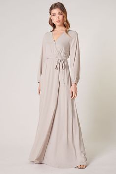 Warm and inviting, the Wholehearted Maxi Dress is a perfect combination of modest and sultry. Long balloon sleeves frame a surplice neckline separated by a tie at the waist, creating a forgiving faux wrap. The skirt maintains an airy and flowy shape that trails behind as you walk down the aisle. - Chiffon- Faux wrap- Keyhole- Elastic waist- Comes in 14 ColorsSize + Fit - Model is 5'9" and wearing size XS- Measurements taken from size S - Chest: 35"- Length: 63 1/4" Fabric Self: 100% PolyesterLin Shoulder Ruffle Dress, Wrap Maxi Dress, Backless Maxi Dresses, Walk Down The Aisle, Long Balloons, Surplice Neckline, Maxi Wrap Dress, Maxi Dress With Sleeves, Balloon Sleeves