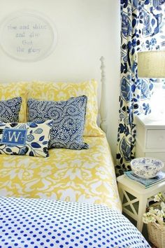 a bedroom with blue and yellow decor on the walls, bedding, and pillows