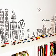 children's toys are lined up on the shelf in front of a city wall mural