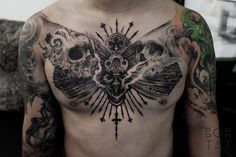 a man with tattoos on his chest has a bird and skull tattoo on it's chest