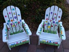 two white lawn chairs with flowers painted on them