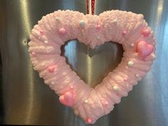 a pink heart shaped wreath hanging on a wall next to a candy cane in the shape of a heart