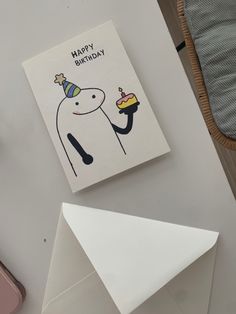 a birthday card sitting on top of a table next to an envelope and some other items