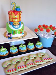 there is a cake and cupcakes on the table