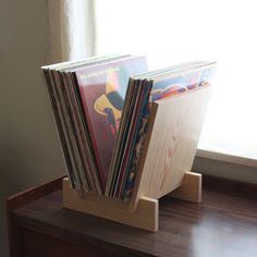 a stack of records sitting on top of a wooden stand