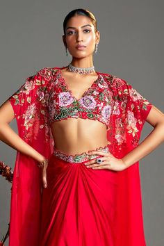 Red floral printed cape embroidered with sequin and beads. Paired with dhoti skirt and padded floral printed blouse embroidered with sequin and beads. - Aza Fashions Traditional V-neck Sharara For Party, Traditional V-neck Party Sets, Red Embroidered V-neck Set, Red V-neck Choli With Zari Work, Bohemian Red Pre-draped Saree For Festive Occasions, Festive Red Pre-draped Saree With Floral Embroidery, Red Bollywood V-neck Set, Red V-neck Bollywood Set, V-neck Navratri Party Sets