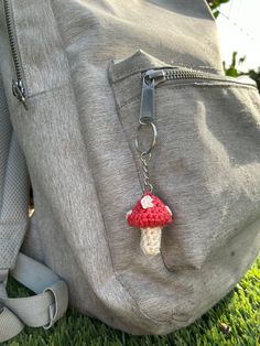 a small mushroom keychain is attached to a backpack