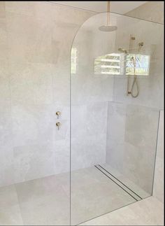 a glass shower door in a white bathroom