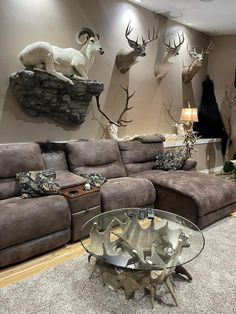 a living room filled with furniture and deer heads on the wall