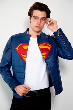 a man wearing a superman jacket and glasses