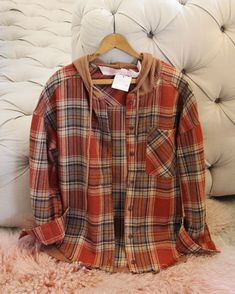 Sweet yet rugged plaid details adorn this cozy hooded shirt jacket. Designed with a button-up front, long sleeves, large front pockets, and a sweatshirt hood. Soft & warm. So cute to bundle up in no matter if you are staying in or going out. Color: Rust Soft poly & cotton blend Hand wash cold Small Medium Large Bust 40 43 46 Waist 40 43 46 Hips 41 42 45 Length 27 27 24 Bust, waist, and hip measurements are a total circumference. Length is measured from the top of the shirt to the hem. Measuremen Casual Hooded Shacket For Fall, Plaid Hooded Flannel Outerwear, Fall Plaid Hooded Jacket With Pockets, Casual Plaid Hooded Jacket With Pockets, Hooded Flannel Outerwear For Fall, Casual Plaid Long Sleeve Hooded Jacket, Casual Hooded Flannel Shirt For Winter, Plaid Cotton Hooded Jacket For Fall, Casual Plaid Hooded Jacket For Winter