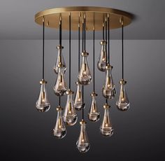 a chandelier hanging from the ceiling with many glass drops in gold and black