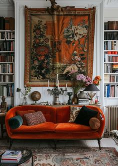 a living room filled with furniture and bookshelves next to a painting on the wall