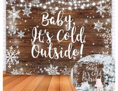 a baby it's cold outside sign with snowflakes on the wood background