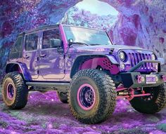 a purple jeep parked in front of a cave