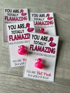 three flamingo magnets with pink text on them