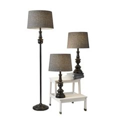 two lamps are sitting next to each other on a white table with a black lamp shade