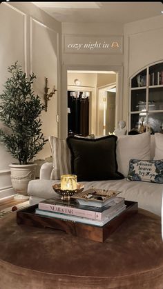 a living room filled with lots of furniture and books on top of a coffee table