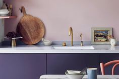 a kitchen with purple walls and white counter tops