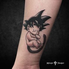 a small tattoo on the arm of a person with a dragon sitting on top of it