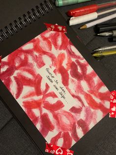 an open notebook with writing on it next to markers and pens