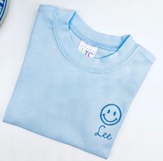 Smiling face t shirt Sizes 12 mo and up. For boys or girls Listing includes name Nice, thicker cotton boutique quality t shirts If you don't see a size here that you need, I will be glad to check to see if I have it. Please message me for questions. Playful Blue Tops With Name Print, Pre-shrunk Crew Neck Top For Daycare, Fun Blue Tops With Name Print, Fun Blue Top With Name Print, Smiling Face, Smile Face, Quality T Shirts, Short Girls, Custom Color