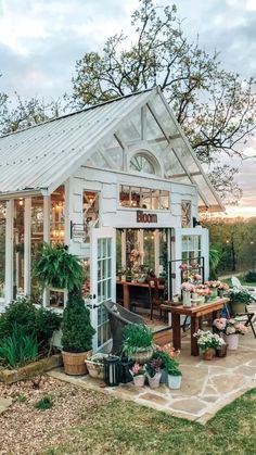 a small white house sitting on top of a lush green field