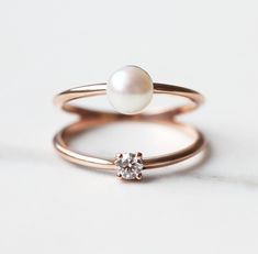 A unique solitaire engagement or birthstone diamond and pearl ring with a double band. Details Gemstone: white diamond Shape: round Measurements: approx. 3mm, 0.10ct Quality: G golour, VS clarity, conflict-free Gemstone: freshwater pearl Shape: round Measurements: approx. 5.5 - 6mm Band measurements: approx. 1.6 mm Material: 14k solid yellow gold, white gold, rose gold or 18k solid yellow gold, white gold, rose gold, (platinum for extra fee) Sizes available: 3-8 (Larger and smaller sizes are ava White Pearl Ring With Single Diamond For Anniversary, White Pearl Ring With Single Diamond, Rose Gold Pearl Ring With Diamond, Rose Gold Diamond Pearl Ring, White Pearl Ring With Single Diamond For Wedding, Fine Jewelry Pearl Ring With Single Diamond For Anniversary, Elegant Stackable Rose Gold Pearl Ring, Wedding Pearl Ring With Single Diamond, Elegant Rose Gold Stackable Pearl Ring