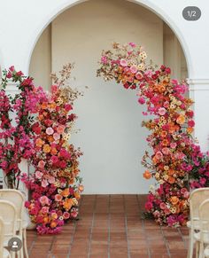 an archway decorated with pink and orange flowers