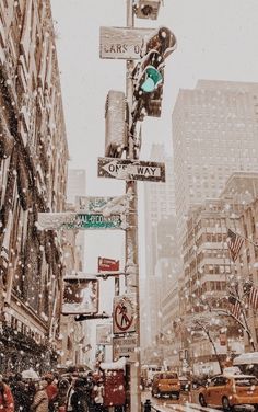 a city street filled with lots of traffic and covered in snow next to tall buildings