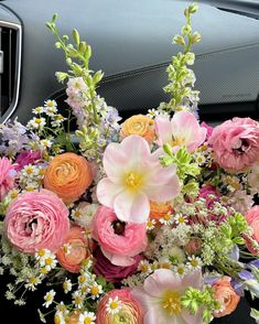 a bouquet of flowers sitting on the dashboard of a car