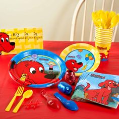 there is a red table with yellow plates and plastic utensils