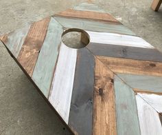 a large wooden board sitting on top of a cement floor next to a table with a hole in it