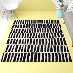 a black and white area rug on the floor in a living room with yellow walls