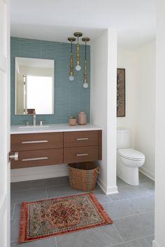 a bathroom with a rug, sink and toilet in it's center piece is shown