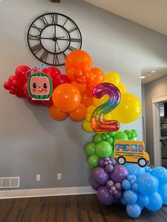 there are many balloons on the wall in this room and one has a car with an odd face on it