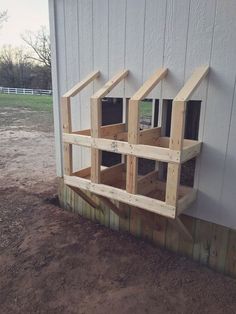 a building made out of wooden boards with windows on the side and bottom part missing