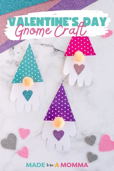 three paper gnomes with hearts on them sitting on a marble surface next to confetti